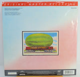 Back cover of a vinyl record sleeve featuring a large watermelon being carried by a red Allman Brothers train against a light blue and pink gradient background.