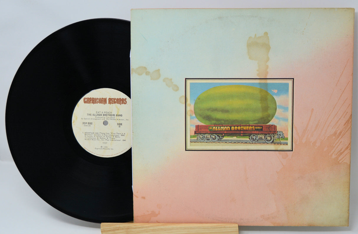 Vinyl record with a colorful album cover featuring a large fruit on a train.