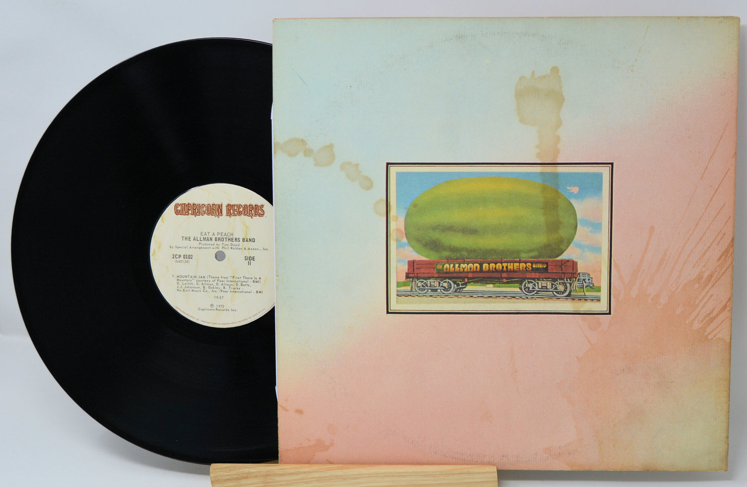 Vinyl record with a colorful album cover featuring a large fruit on a train.