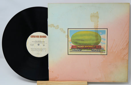 Vinyl record with a colorful album cover featuring a large fruit on a train.
