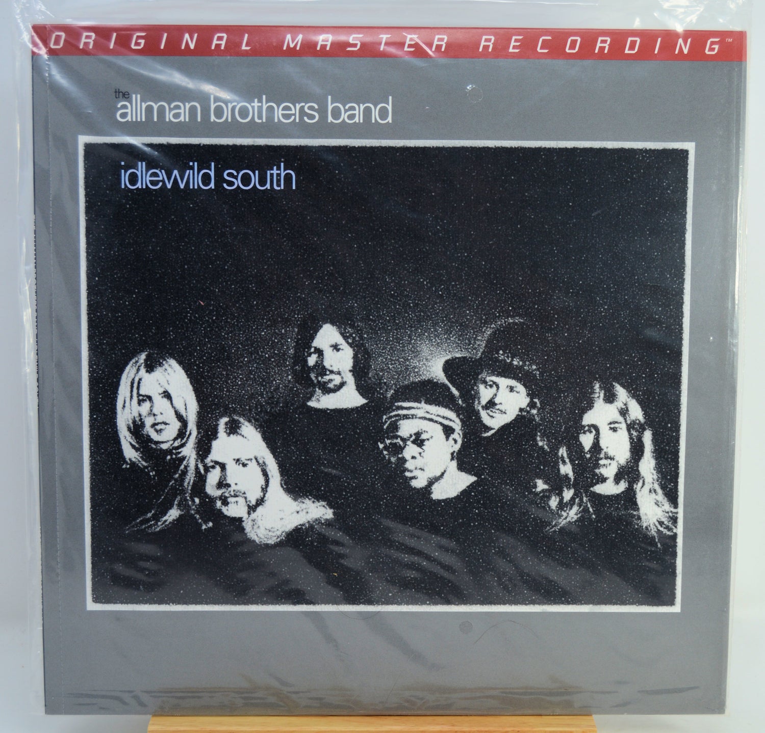 Allman Brothers Band 'idewild south' original master recording vinyl LP album cover, sealed in plastic shrink wrap, displayed on a wooden stand.