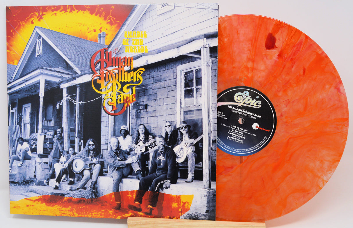 The Human Family's 'We're All Goin' Down the Road' vinyl record album with its illustrated cover sleeve and a translucent orange record partially visible behind it.