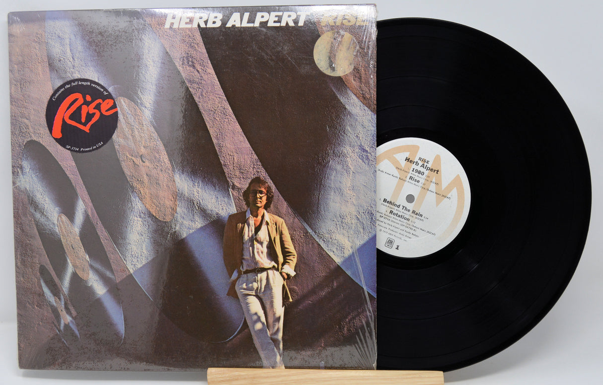 Vinyl record with cover featuring a person and abstract design, on a white background