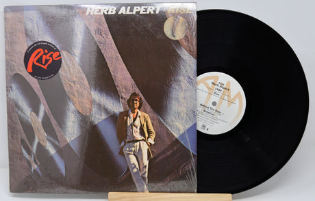 Vinyl record with cover featuring a person and abstract design, on a white background