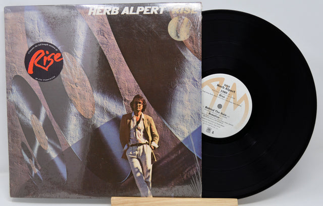 Vinyl record with cover featuring a person and abstract design, on a white background