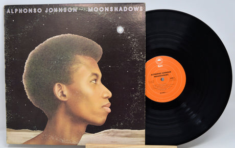Alphonso Johnson's Moonshadows vinyl record LP with its illustrated album cover and the black record partially pulled out, showing the orange center label.