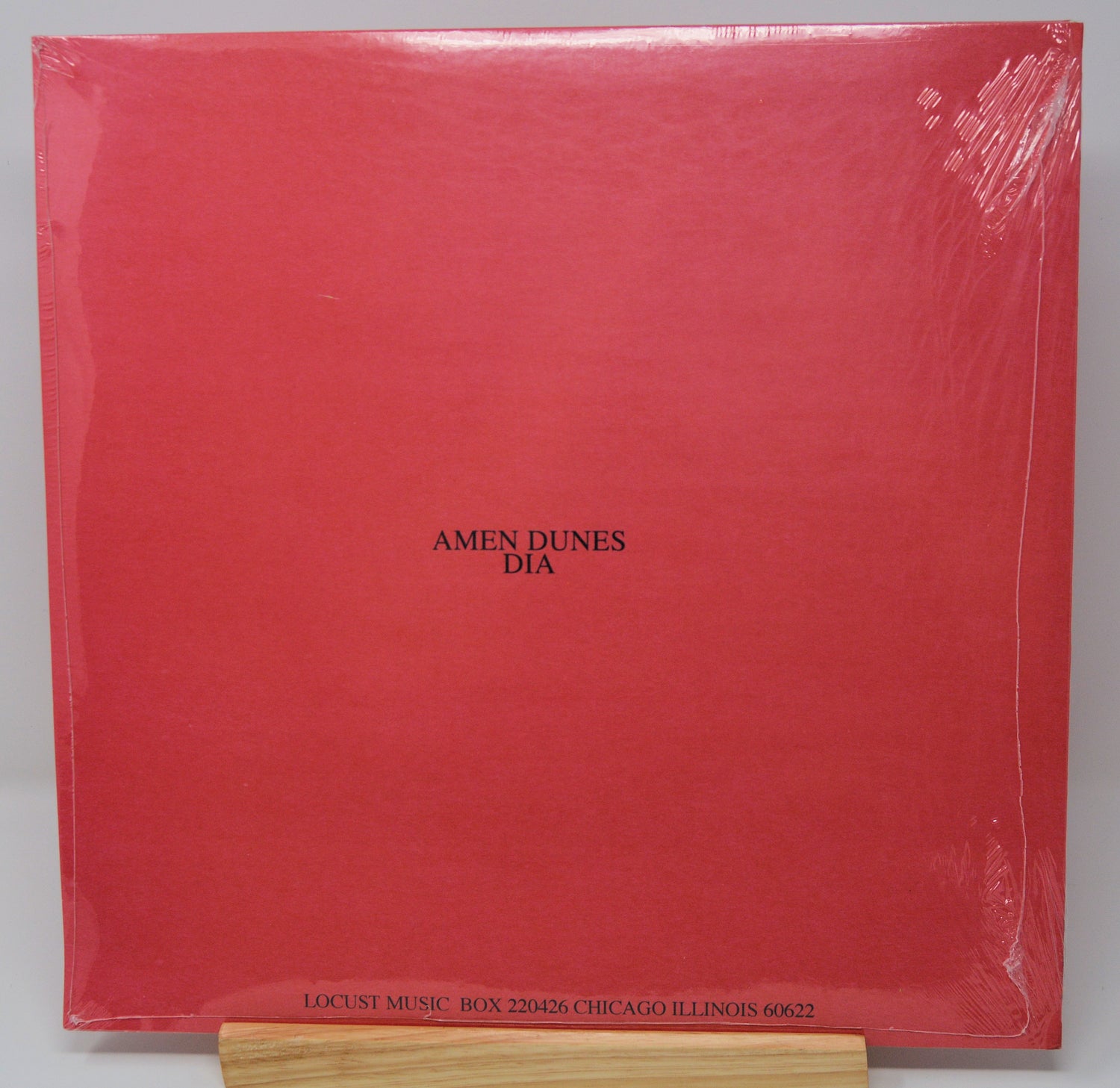 A red vinyl record cover featuring a black and white image of a person's face superimposed on a red background with the text 'DIA' at the top.