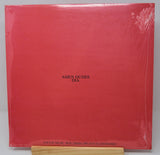 A red vinyl record cover featuring a black and white image of a person's face superimposed on a red background with the text 'DIA' at the top.