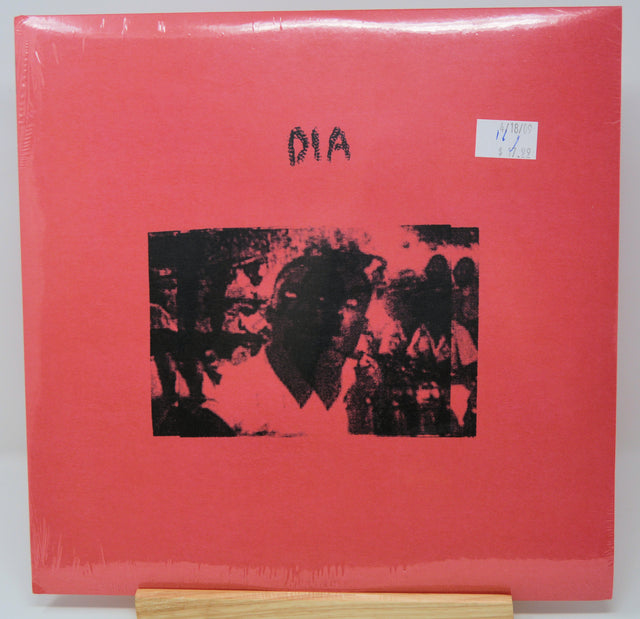 A red vinyl record cover featuring a black and white image of a person's face superimposed on a red background with the text 'DIA' at the top.