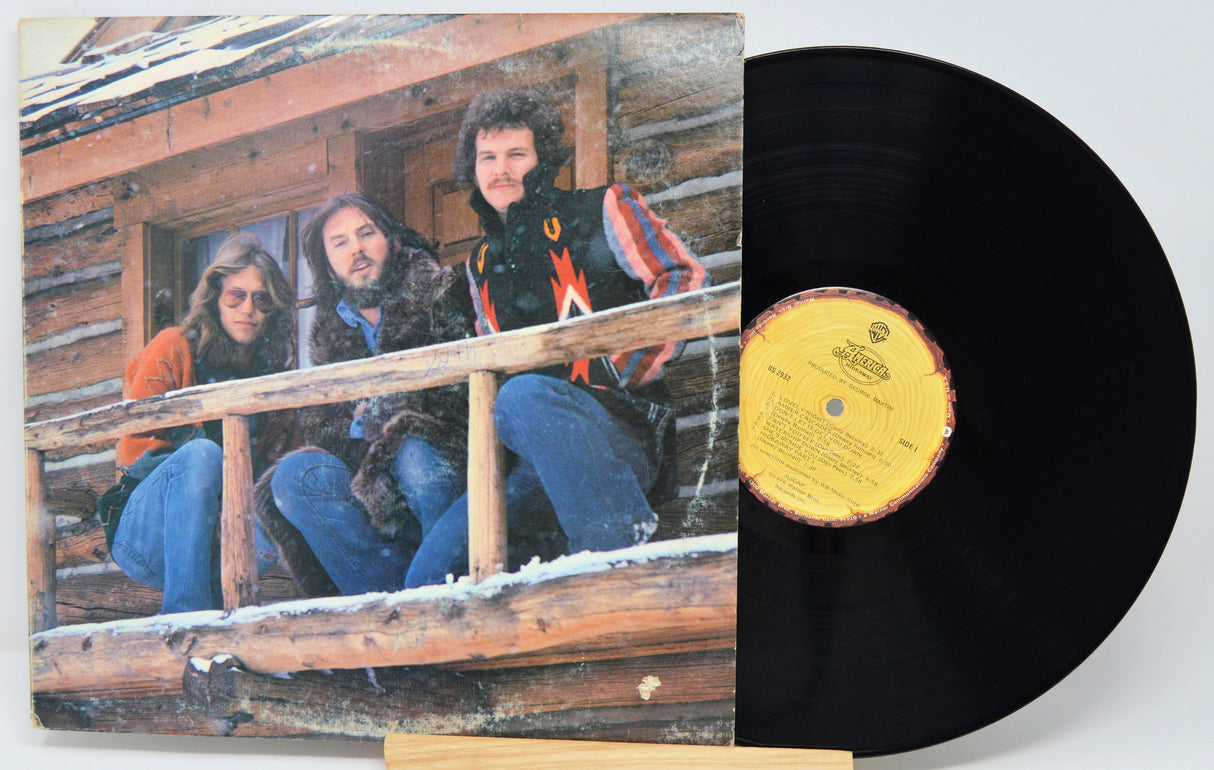 Vinyl record with cover showing three people on a wooden porch, featuring a yellow label.