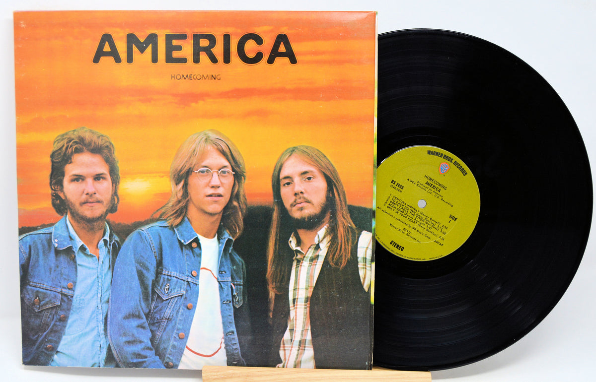 Vinyl record with cover featuring three individuals and 'America' album title.