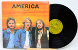 Vinyl record with cover featuring three individuals and 'America' album title.