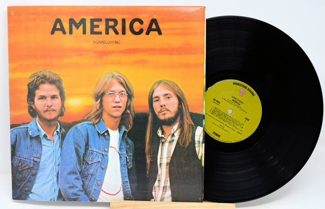 Vinyl record with cover featuring three individuals and 'America' album title.