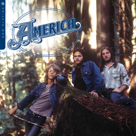 America band members posing on a mossy log in a sunlit forest for the Now Playing album cover