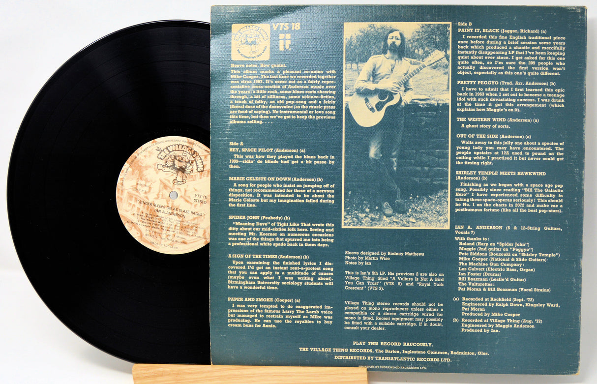 Vinyl record with its cover featuring text and a photo of a person playing guitar.