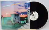 Vinyl record with cover featuring a scenic design on a white background