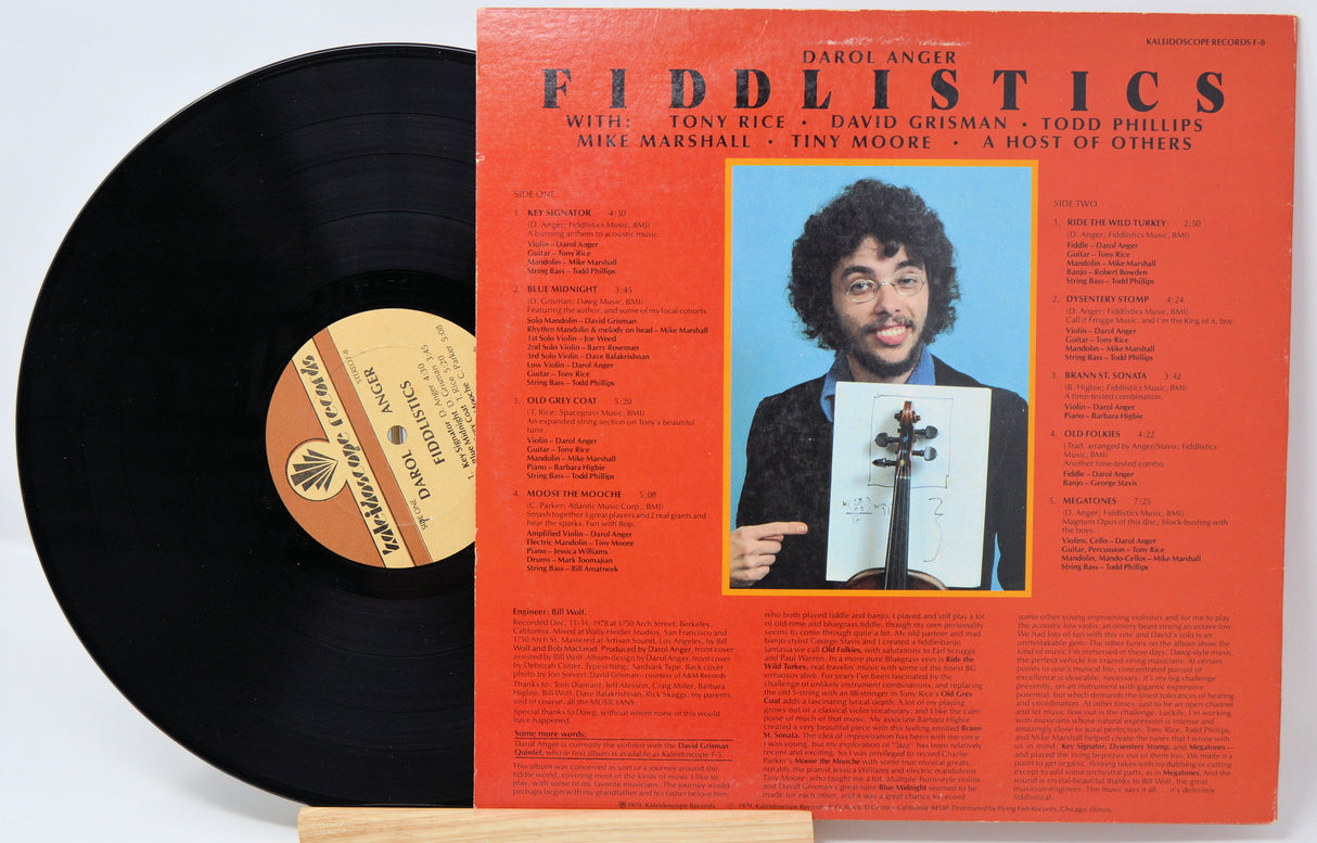 Vinyl record and back cover for Fiddlistics by Darol Anger showing a picture of him and lots of black text on a red background.