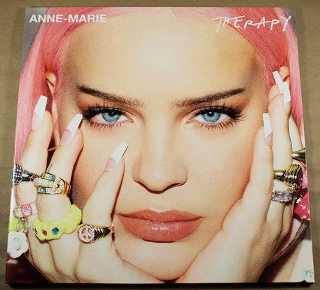 Album cover with a person with pink hair and jewelry, featuring the text 'Anne-Marie Therapy'.