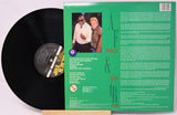 Vinyl record with green label featuring two people and text on a white background