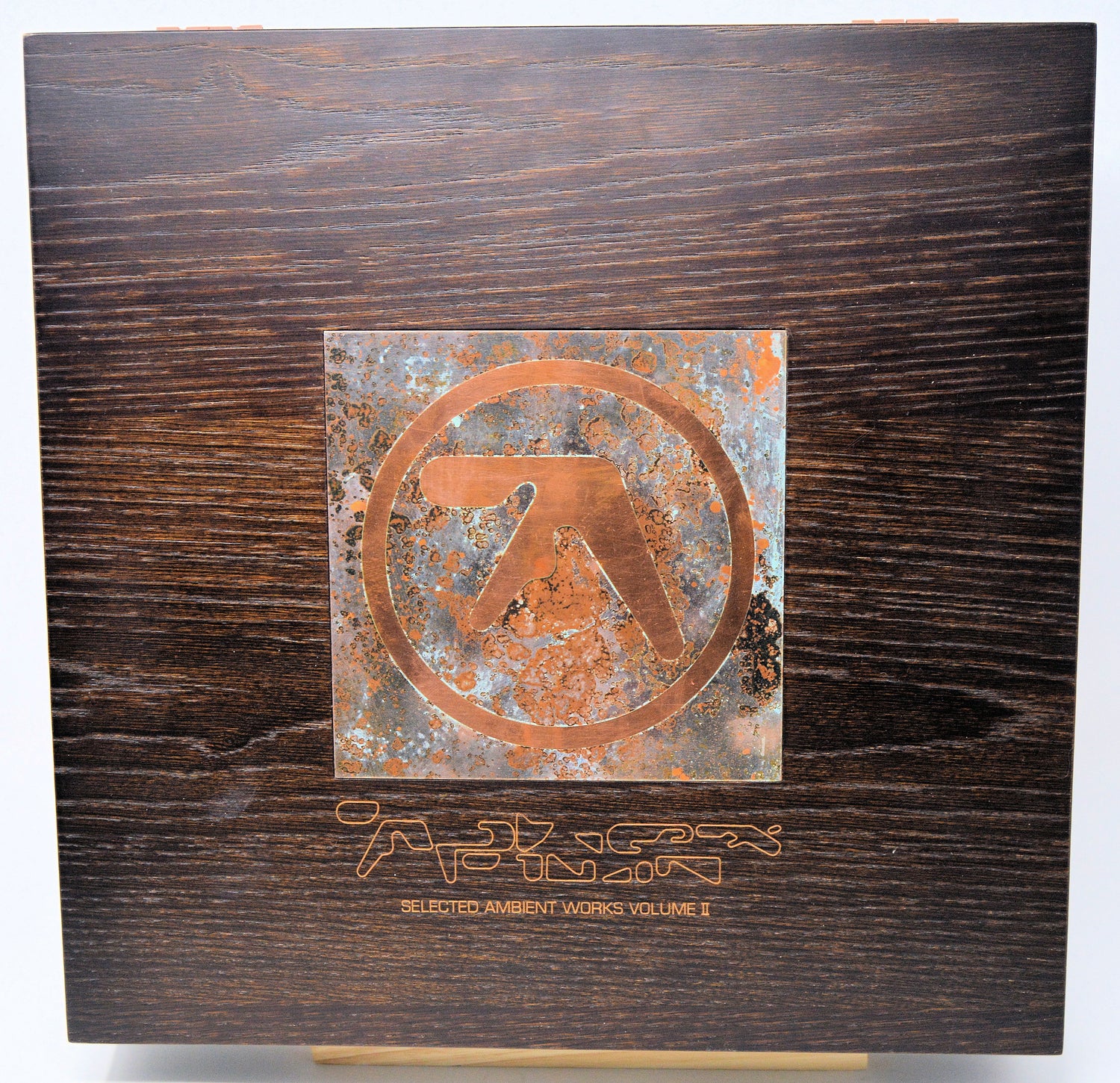 Wooden box with a metal emblem and text on a white background