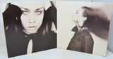 Album cover with black and white portraits of a woman on a light blue background