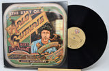 Vinyl record with cover featuring Woody Guthrie and text on a white background