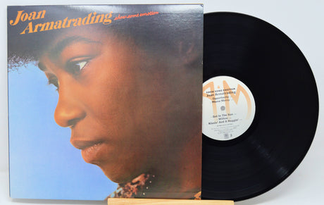 Vinyl record with cover featuring a close-up of a person's face, on a light gray background.