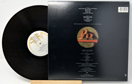 A vinyl record titled 'Sleight Of Hand' by Joan Armatrading with the album cover showing the artist's face and a guitar. The record is placed in front of the cover.
