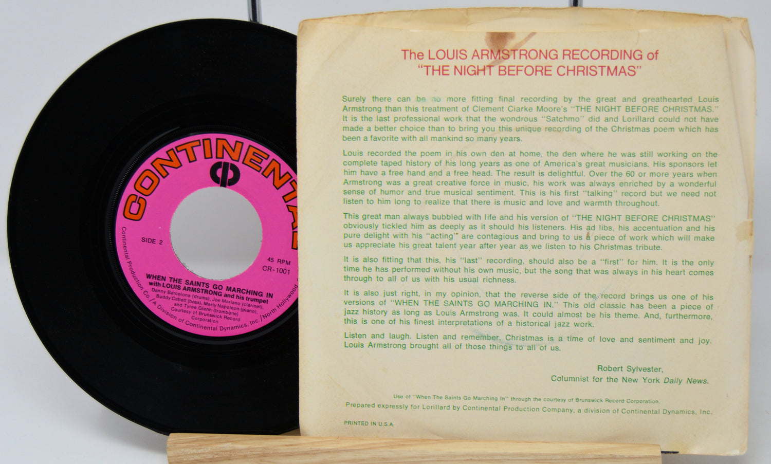 Vinyl record with pink label and record cover featuring text on a white background
