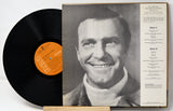 Vinyl record with a portrait of a man on the cover and an orange label.