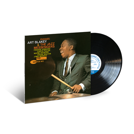 Vinyl record with cover featuring a musician playing drums, on a white background