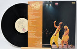 Vinyl record with cover featuring a band on stage