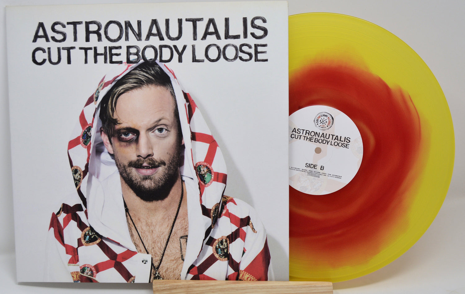 Vinyl record of Astronautalis album 'Cut The Body Loose' with a yellow and red cover featuring the artist's image.