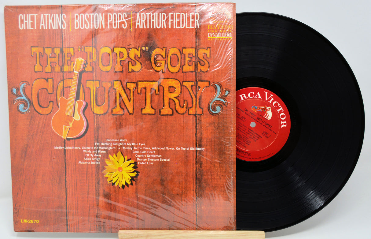 Vinyl record with orange cover featuring text and graphics, on a white background