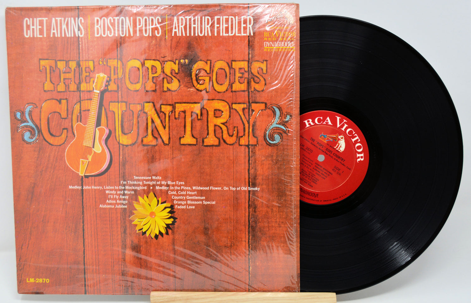 Vinyl record with orange cover featuring text and graphics, on a white background