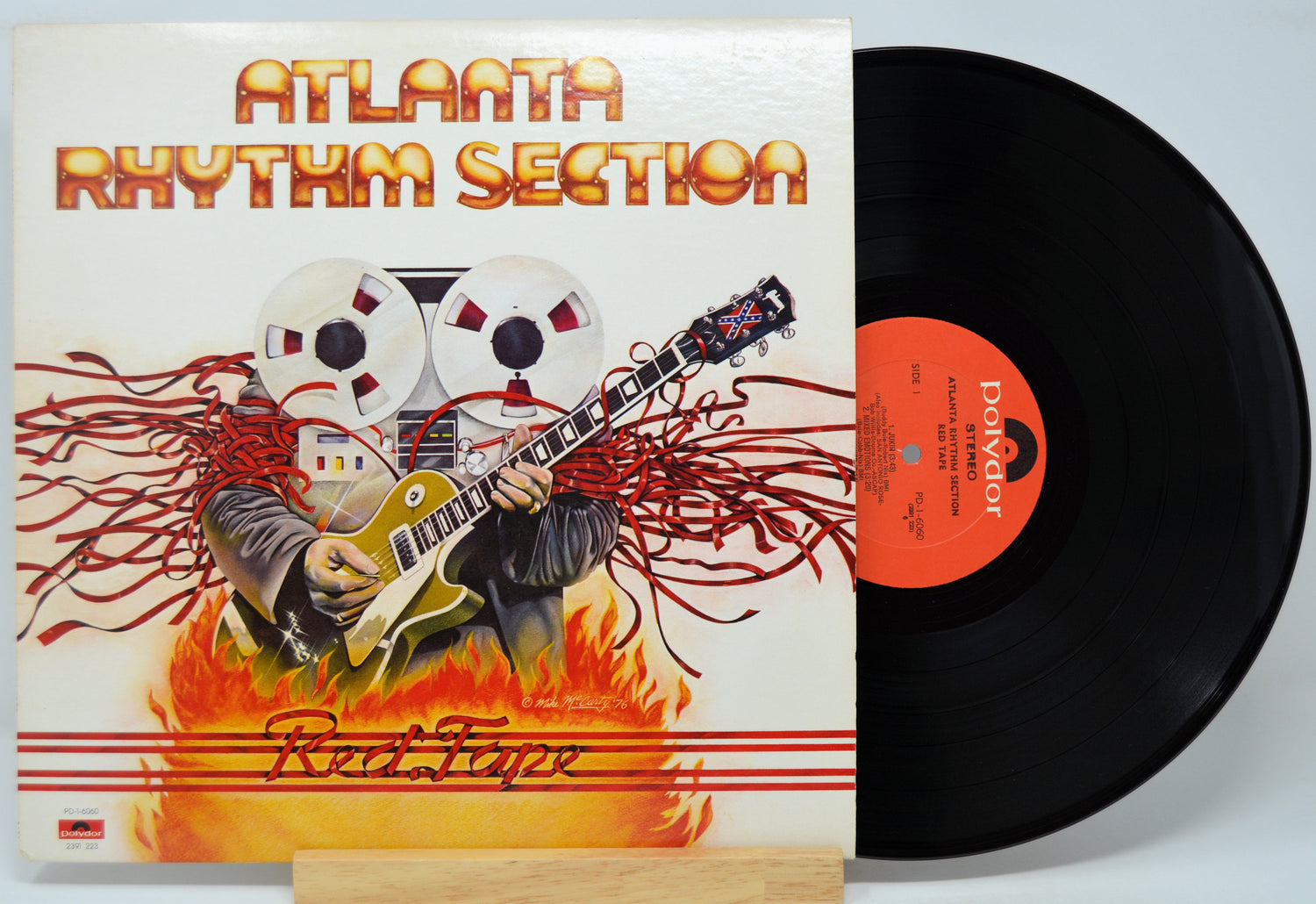 Vinyl record with cover featuring a guitar and reel-to-reel tape, labeled 'Atlanta Rhythm Section' and titled 'Red Tape'.