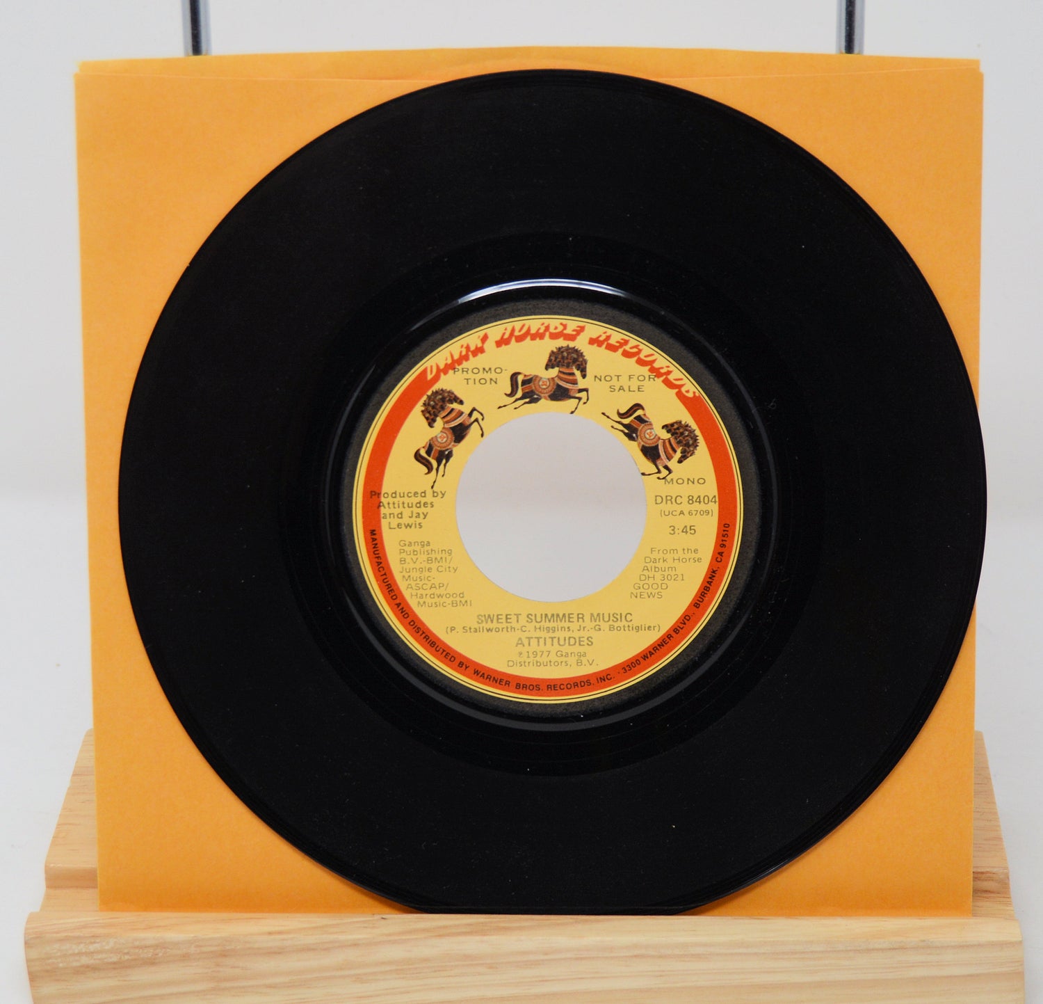 A vinyl record titled 'Sweet Summer Music' by The Spinners, with an orange record label and a black vinyl record.