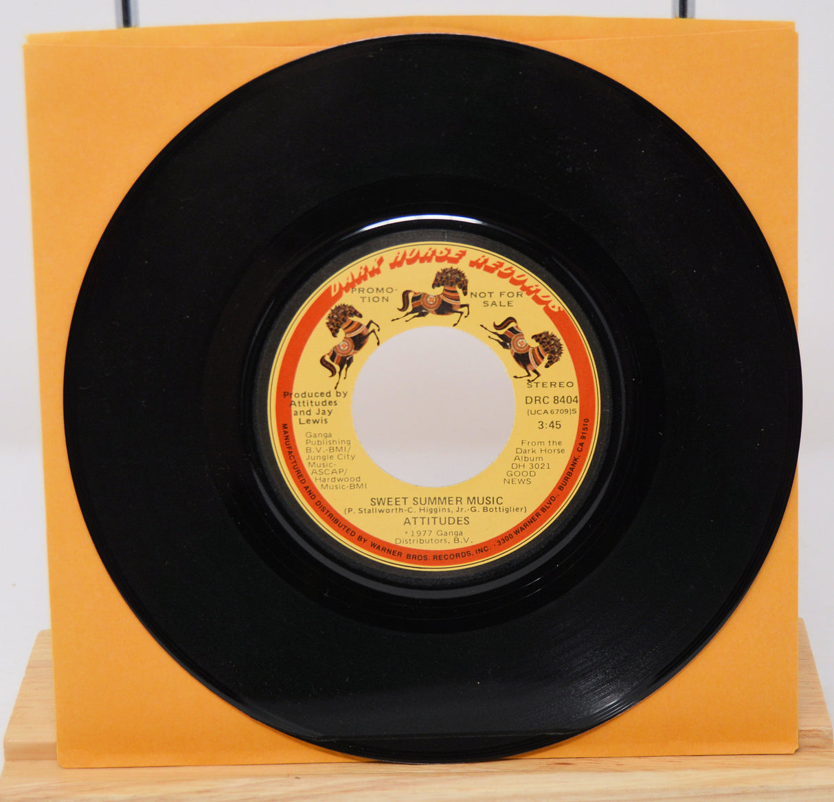 A vinyl record titled 'Sweet Summer Music' by The Spinners, with an orange record label and a black vinyl record.
