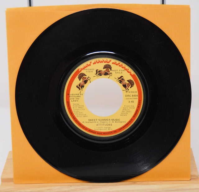 A vinyl record titled 'Sweet Summer Music' by The Spinners, with an orange record label and a black vinyl record.