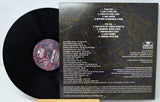 A vinyl record and its cover featuring a colorful abstract design with the artist and album name 'Attractors - Love Bombs'.