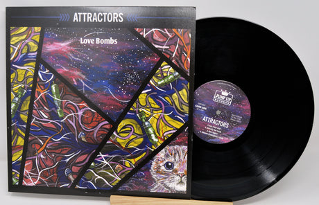 A vinyl record and its cover featuring a colorful abstract design with the artist and album name 'Attractors - Love Bombs'.