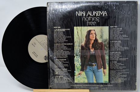 Vinyl record with cover featuring a woman and album details on a white background