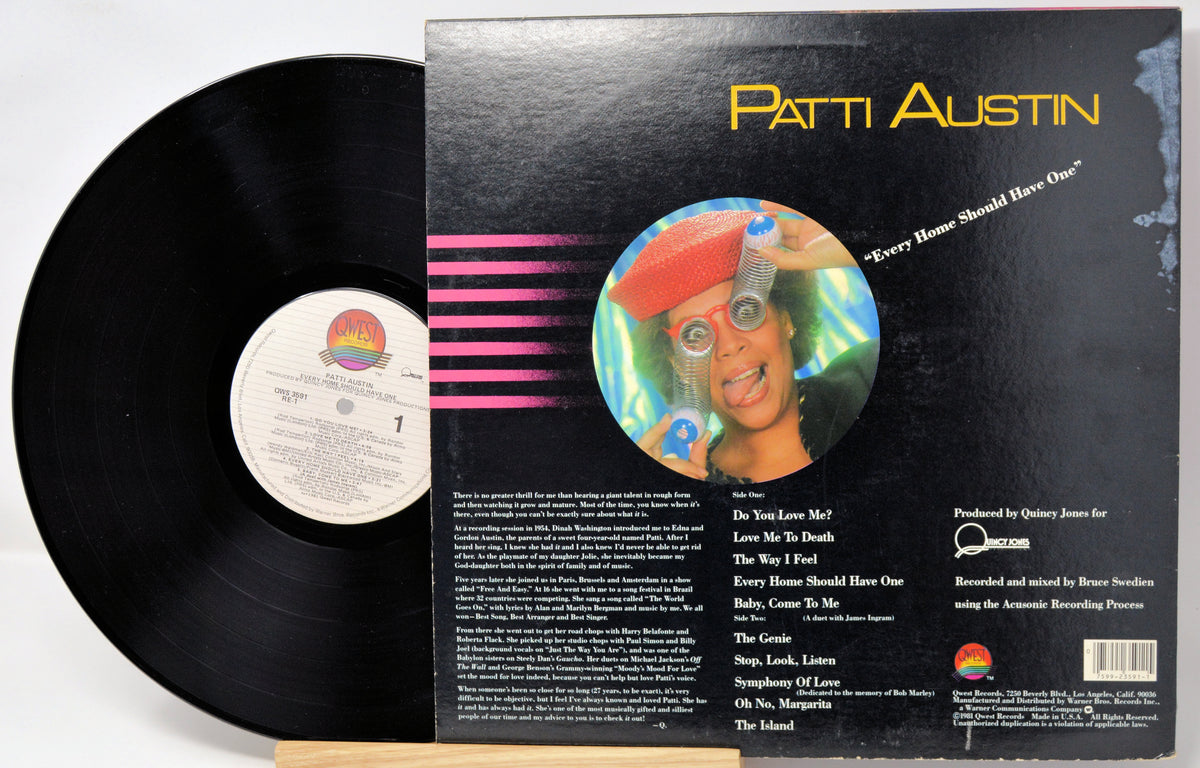 A vinyl record partially pulled from its black outer sleeve, showing the back cover artwork and track list. The record label includes Patti Austin and a colorful circular portrait on the cover.
