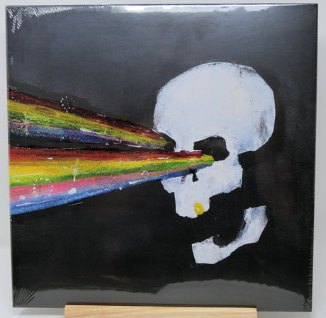 Artistic depiction of a skull with a rainbow-colored tongue against a black background