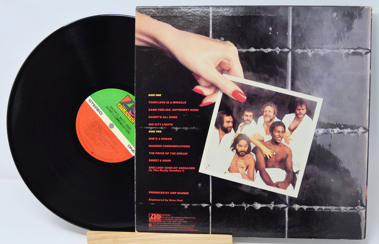 Vinyl record with a photo sleeve featuring a group of people on a tiled wall background