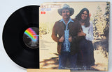 Vinyl record with cover featuring a couple in a natural setting
