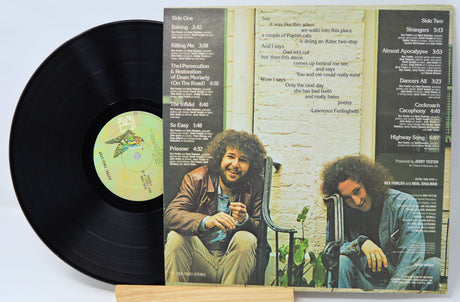 Vinyl record with cover featuring two people sitting on a bench.