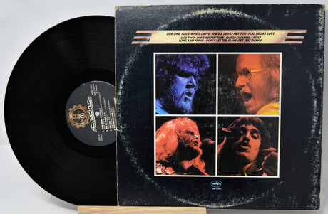 Vinyl record with its cover featuring four album covers of a famous band.