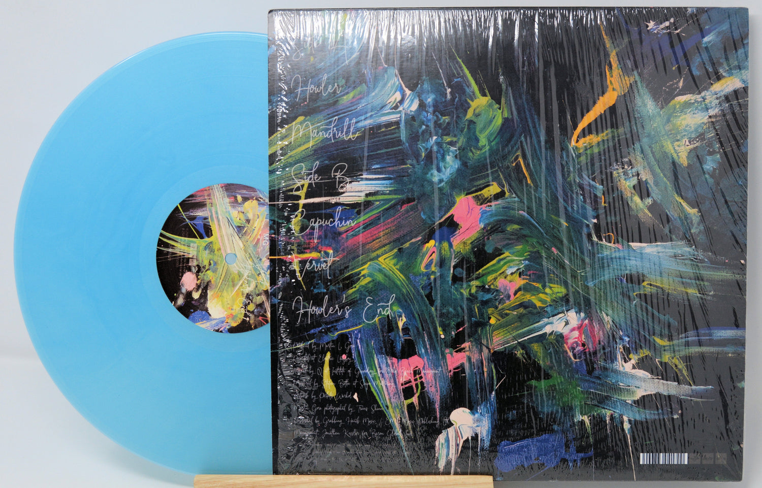 Back cover and azure blue vinyl of Martin Gore's The Third Chimpanzee EP, featuring abstract colorful artwork