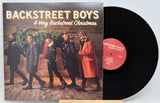 Backstreet Boys A Very Backstreet Christmas vinyl cover with band carrying a Christmas tree indoors